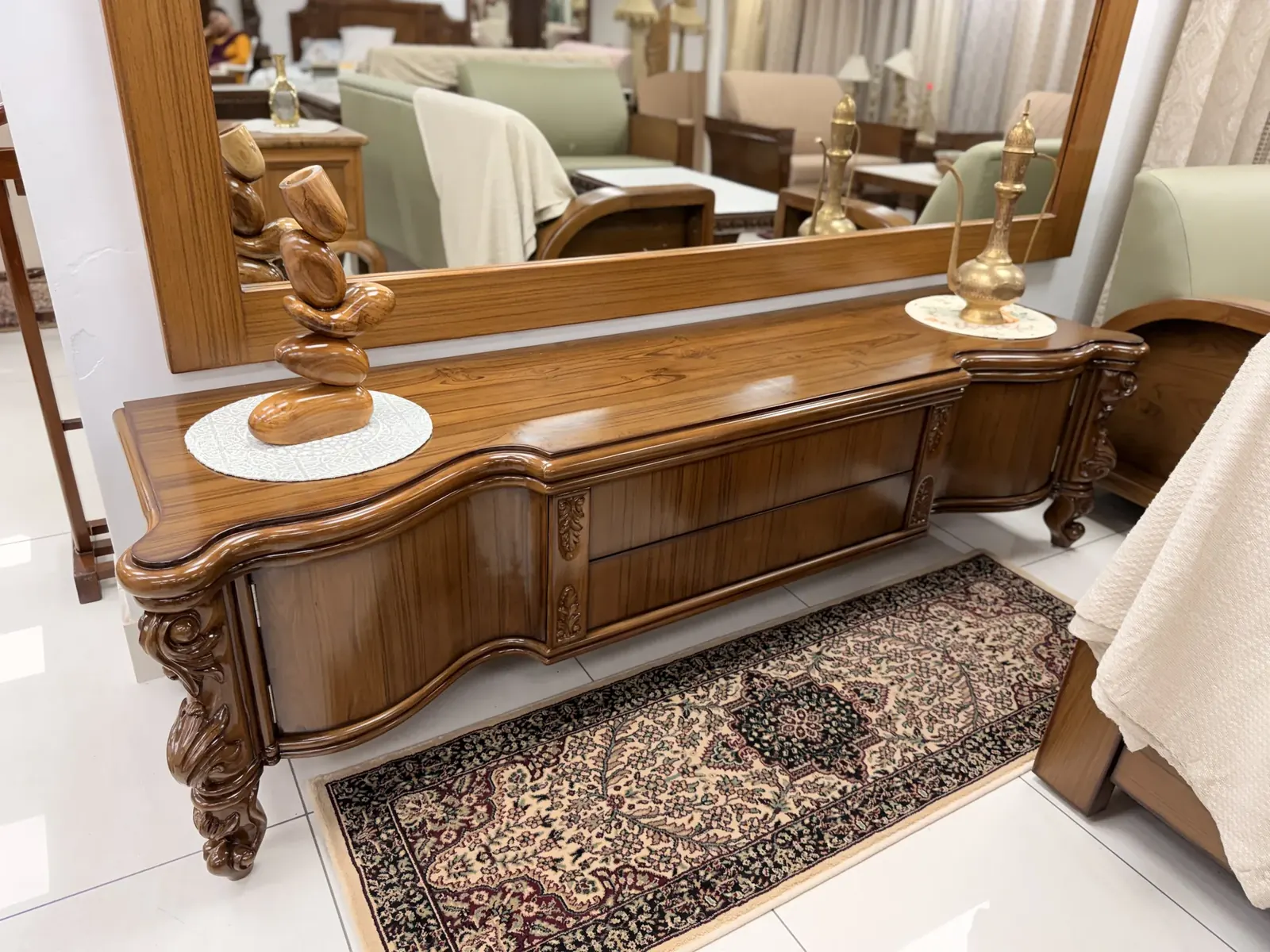 Hand-polished serpentine teak credenza with bookmatched flame grain and carved wall mirror