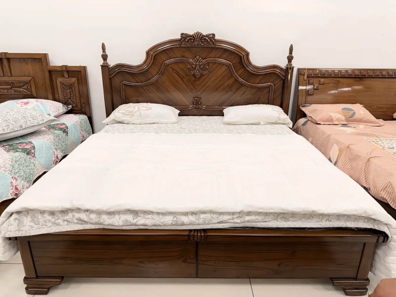 Finished solid teak Maharaja bed with bookmatched chevron grain headboard and carved finials